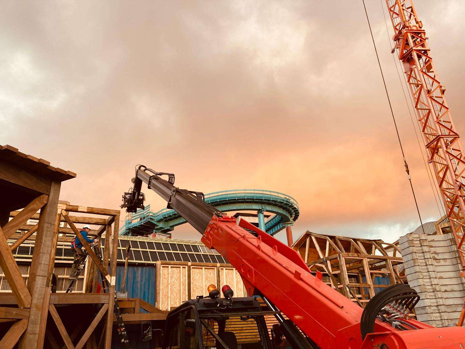 Bras de grue et charpentes de Dock World sous un ciel de crépuscule